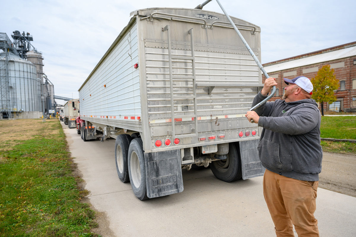 Robb Ewoldt opens a truck bin of soybeans to be transported into a barge.