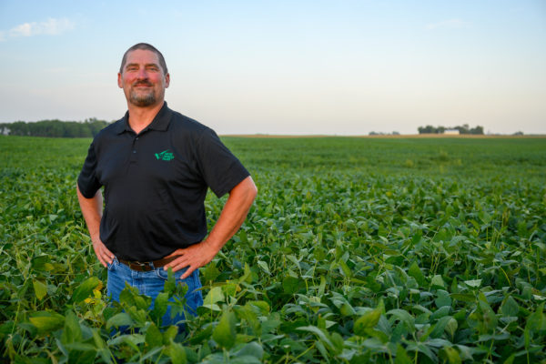 Farmer-leader Tim Bardole stands in an open soybean field.