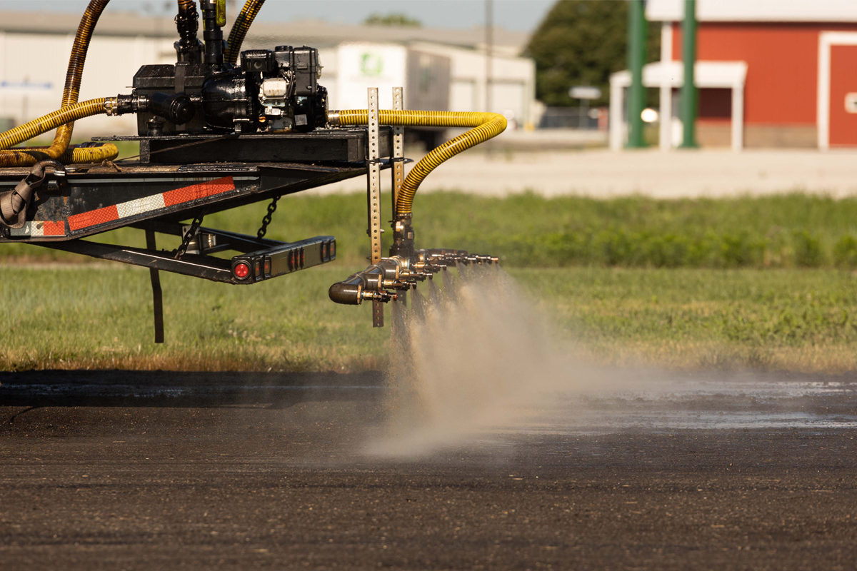 A machine sprays a soy solution as a new type of asphalt pavement.