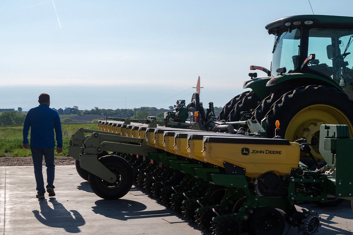 Ron Pavelka, Nebraska farmer-leader, walks behind a John Deere soy planter.
