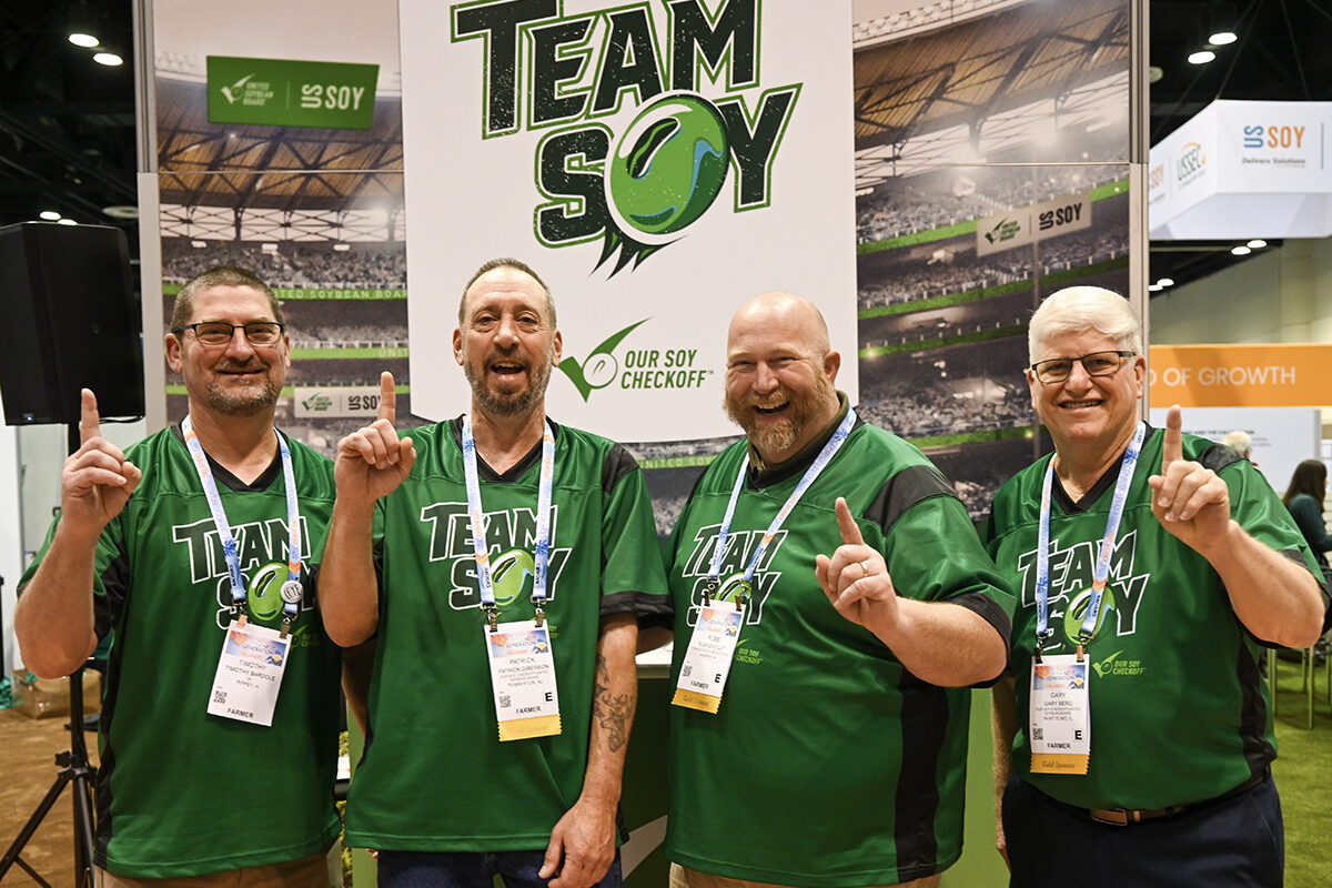 Farmers at the Commodity Classic Team Soy booth hold up index fingers to show "number one".