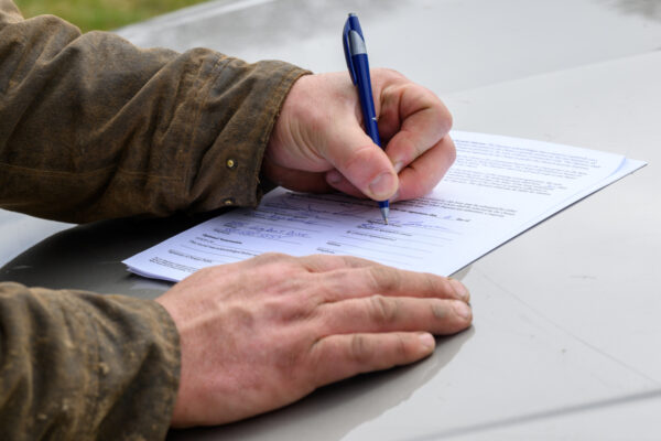 Farmer signing a contract.