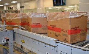 Boxes of Edesia food products travel down an assembly line.